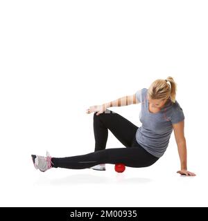 Serrer les muscles de sa cuisse. Une jeune femme s'entraîner à l'aide d'une balle d'exercice. Banque D'Images