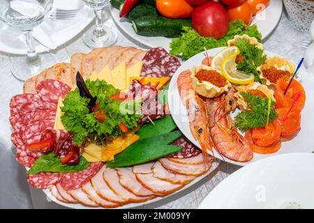 Coupez la viande et les fruits de mer sur la table des fêtes. De délicieux en-cas froids sont prêts à manger. Banque D'Images