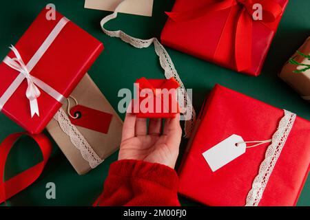 Directement au-dessus de la main de la femme tenant une boîte à anneaux avec des cadeaux pour la Saint-Valentin Banque D'Images