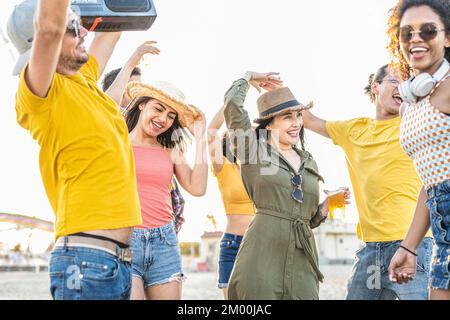 fête dansante à la plage, groupe de jeunes femmes et hommes de différentes origines s'amusant, dansant et riant lors d'un événement festif d'été, Banque D'Images