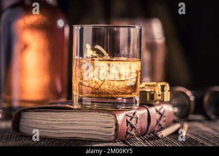 Whisky noble et vieilli sur le rocher avec journal et boussole. Whisky single malt avec glace. Banque D'Images