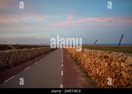 Mur en pierre sèche sur la route du phare de Punta Nati au coucher du soleil sur l'île des Baléares de Minorque, Espagne. Banque D'Images