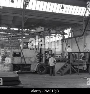 1950s, historique, steelworks, une grue de levage à rapier électrique (EME-1) de levage de la pile de tôles d'acier à l'Abbey Works, Port Talbot, pays de Galles du Sud, Royaume-Uni. La grue mobile a été fabriquée à Ipswich, dans le Suffolk, en Angleterre, par Ransomes & Rapier, l'un des principaux fabricants britanniques d'équipements et de machines ferroviaires pour travaux lourds, une entreprise qui remonte à 1869, et qui a finalement fermé plus de 100 ans plus tard en 1987. Banque D'Images