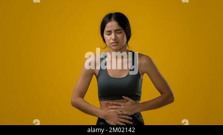 Malade Femme indienne souffrant de douleurs d'estomac tenant le ventre sensation de douleur menstruelle abdominale symptômes gastrite diarrhée malaise douloureux Banque D'Images