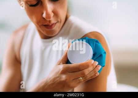 Femme tenant la presse froide sur le bras Banque D'Images