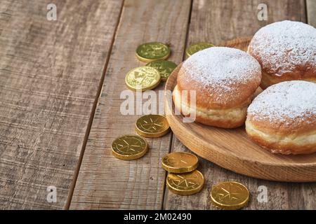 Bonne Hanoukkah. Beignets sucrés Hanukkah, boîtes-cadeaux, bougies blanches et pièces de chocolat sur fond de bois ancien. Image et concept de vacances juives Banque D'Images