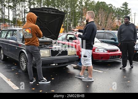 Durham, NC, États-Unis, 3rd décembre 2022, les passionnés de voitures discutent avec le propriétaire d'un wagon de station Volvo classique d'un échange de moteur de V8 lors de l'événement mensuel Cars and Coffee. Credit D Guest Smith / Alamy Live News Banque D'Images