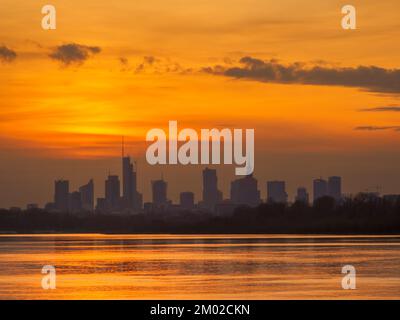 Panorama de Varsovie avec gratte-ciel dans le centre ville avec une belle réflexion du soleil à Wisła et des bateaux naviguant sur la rivière pendant le coucher du soleil Banque D'Images