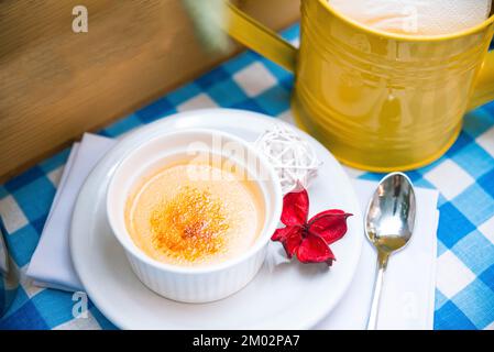 une portion de crème brûlée délicate en ramequin sur la table d'une serviette à carreaux Banque D'Images