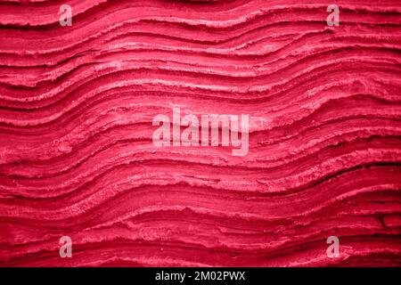 texture d'un motif ondulé sur un mur en béton de couleur viva magenta de l'année 2023 Banque D'Images