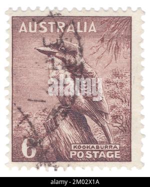 AUSTRALIE — 1942: Timbre-poste brun-violet de 6 pence représentant les séries Kookaburra (Kingfisher), King George VI et Queen Elizabeth. Les kookaburras sont des pêcheurs terrestres d'arbres du genre Dacelo, originaire d'Australie et de Nouvelle-Guinée, qui mesurent entre 28 et 47 cm (11 et 19 po) de longueur et pèsent environ 300 g (11 oz). Le nom est un mot d'ordre de Wiradjuri guuguubarra, onomatopoeic de son appel. L'appel fort et distinctif du kookaburra qui rit est largement utilisé comme effet sonore dans les situations qui impliquent un environnement de brousse australien ou de jungle tropicale, en particulier dans les films plus anciens Banque D'Images