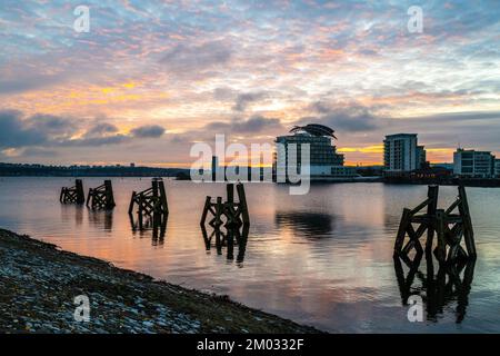 Baie de Cardiff au coucher du soleil, en regardant vers Penarth avec les vestiges des anciennes jetées en bois au premier plan. Banque D'Images