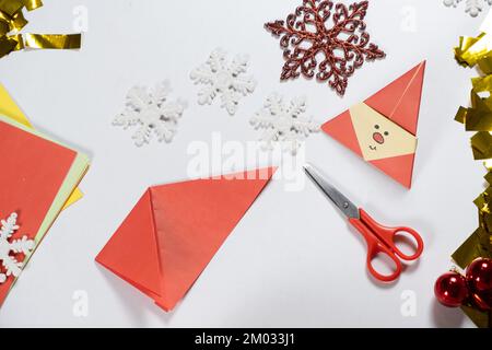 Création d'artisanat d'origami à partir de papier pour Noël et le nouvel an, figurine du Père Noël. Banque D'Images