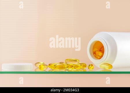 Oméga 3. Composition de soins de santé avec vitamines naturelles D3 sur étagère en verre sur fond rose avec espace de copie. Bouteille blanche avec suppléments sains dans Banque D'Images