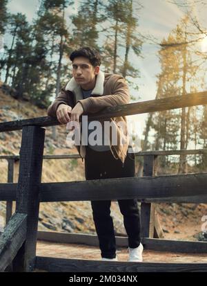 Jeune homme attrayant dans les montagnes en automne ou en hiver Banque D'Images