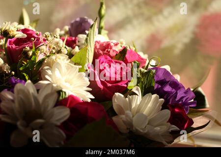 Un bouquet de roses roses, lilas fleurs de l'Alstroemeria blanc et petits chrysanthèmes, debout près de la fenêtre, éclairé par les rayons de soleil Banque D'Images