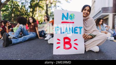 Bonne fille musulmane tenant une affiche « pas de planète B » lors d'une manifestation sur le changement climatique. Des jeunes militants multiculturels protestant contre le réchauffement climatique. OUI Banque D'Images