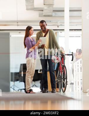 Faire les livraisons de jours. Prise de vue en longueur d'un beau messager de vélo dans un bureau. Banque D'Images