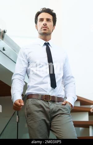 Envisager des affaires. Un bel homme en costume qui pose sur un escalier. Banque D'Images