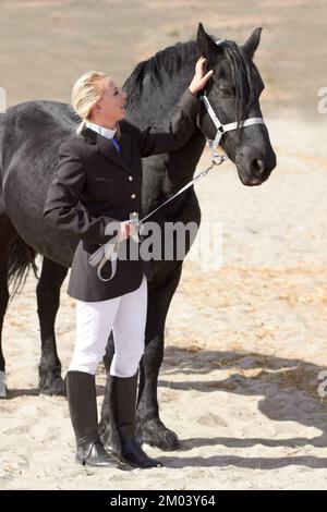 Un peu d'attention va beaucoup. Photo en grand angle d'une jeune femme pilote qui a affectueusement porté son cheval. Banque D'Images