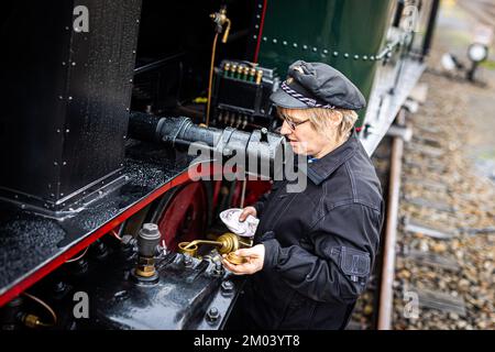 Bruchhausen Vilsen, Allemagne. 26th novembre 2022. La locomotive à vapeur Insa Drechsler-Konukiewitz travaille sur une locomotive du chemin de fer du musée dans le district de Diepholz. Le natif de Brême est l'un des seuls pilotes de locomotives à vapeur femelles. Elle forme également le personnel junior sur le chemin de fer du musée à Bruchhausen-Vilsen. Credit: Moritz Frankenberg/dpa/Alay Live News Banque D'Images