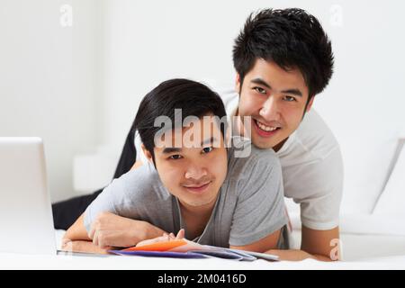 Passer la journée ensemble. Portrait d'un jeune couple gay qui se détend au lit. Banque D'Images