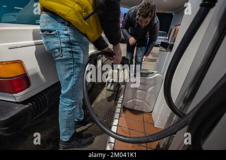 Les personnes qui remplissent des bidons de gaz ou des canisters en raison de l'augmentation du prismes de l'essence ou du diesel. Beaucoup de gens sur la station-service de remplissage de gaz dans des bidons. Banque D'Images