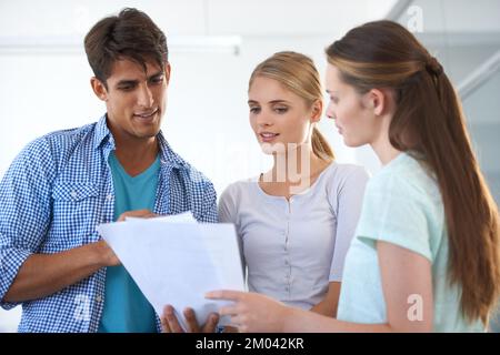 C'est la proposition. Trois jeunes collègues travaillant au bureau. Banque D'Images