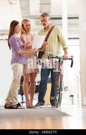 Faire les livraisons de jours. Prise de vue en longueur d'un beau messager de vélo dans un bureau. Banque D'Images