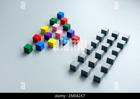 Des lignes de cubes gris et une pyramide de cubes multicolores comme concept de diversité. Banque D'Images