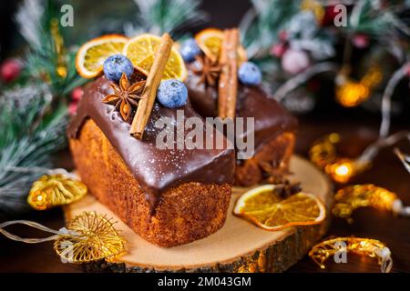 Gâteau du nouvel an avec une délicate pâte crémeuse et des raisins secs décorés d'épices, de myrtilles et de tranches d'orange séchées Banque D'Images