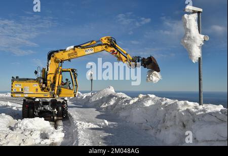 La pelle hydraulique bidirectionnelle libère les pistes de neige à la gare de Brocken, dans les montagnes du Harz, en Saxe-Anhalt, en Allemagne, en Europe Banque D'Images