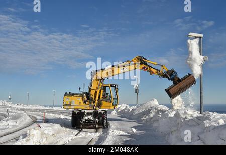 La pelle hydraulique bidirectionnelle libère les pistes de neige à la gare de Brocken, dans les montagnes du Harz, en Saxe-Anhalt, en Allemagne, en Europe Banque D'Images