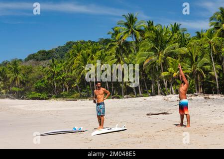 Surfeurs se réchauffant sur la plage de Santa Teresa, la péninsule de Nicoya, Guanacaste, Costa Rica, Amérique centrale Banque D'Images