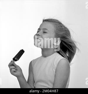 Crème glacée dans le 1960s. Une jeune fille a une glace au chocolat. Suède 1965 Kristoffersson réf. CS95-8 Banque D'Images