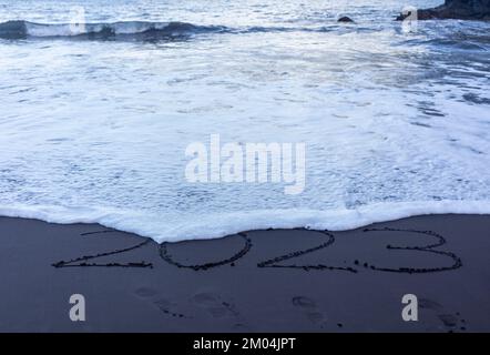 Symbole de l'année 2023 écrit sur du sable noir de plage Banque D'Images