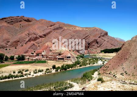 La rivière Hari (Harirud) près de Chisht-e-Sharif dans la province de Herat, en Afghanistan. La rivière traverse un paysage de montagne coloré et passe devant un village. Banque D'Images