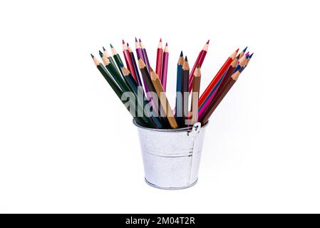 crayons multicolores dans un verre à vin et un seau. Flou sélectif un groupe de crayons de couleur dans un verre de vin sur le dos blanc ou noir isolé Banque D'Images