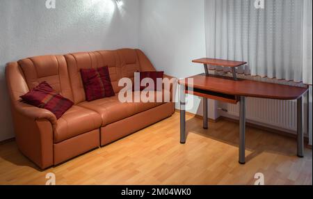 Le salon de l''appartement comprend un luxueux canapé en cuir et un bureau Banque D'Images