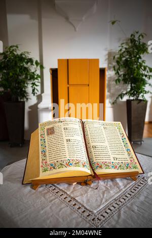 Embrach, Suisse - 23 octobre 2022 : un livre biblique ouvert sur une table dans l'église évangélique réformée d'Embrach. Banque D'Images