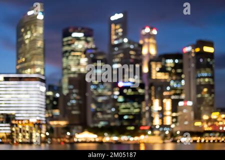 Image floue bokeh de gratte-ciel autour de Marina Bay à Singapour la nuit Banque D'Images