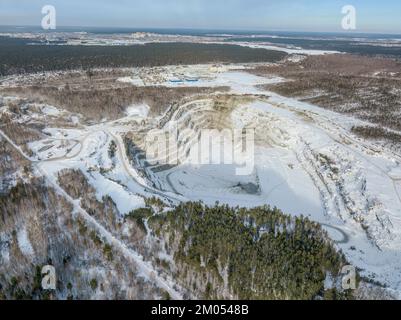 Vue aérienne de la carrière de pierre concassée en hiver avec de la neige. Exploitation de la pierre concassée en hiver. Banque D'Images