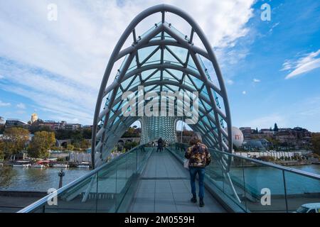 Tbilissi, GÉORGIE: 05 - 10 - 2022: Le pont de la paix est un pont piétonnier moderne en forme d'arc au-dessus de la rivière Kura dans la vieille ville de Tbilissi, en Géorgie Banque D'Images