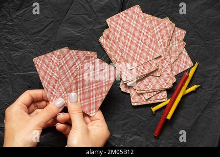 cartes dans les mains d'un tueur de fortune et bougies sur la table, tueur de fortune avec des cartes, magie de dire de fortune Banque D'Images