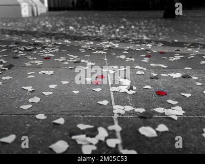 Pétales de rose rouge et petit papier blanc en forme de coeur sur le terrain lors de la cérémonie de mariage, Cracovie, Pologne, noir et blanc, mise au point sélective Banque D'Images