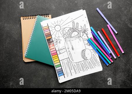 Page de coloriage, stylos-feutres et carnets sur fond sombre Banque D'Images