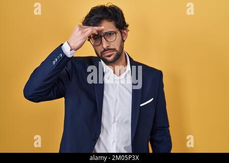 Beau latin homme debout sur fond jaune inquiet et stressé au sujet d'un problème avec la main sur le front, nerveux et anxieux pour la crise Banque D'Images