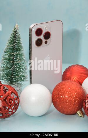 Riga/Lettonie - 4 décembre 2022: Nouveau téléphone moderne- iPhone 14 pro parmi les décorations de Noël scintillantes sur fond noir. Conce cadeau de Noël Banque D'Images