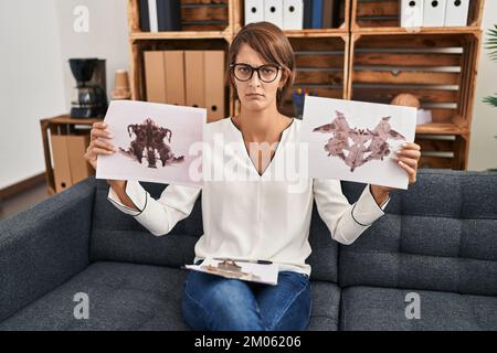 Brunette femme travaillant avec le test de rorschach à la clinique de psychologie sceptique et nerveux, frognant bouleversé à cause du problème. personne négative. Banque D'Images