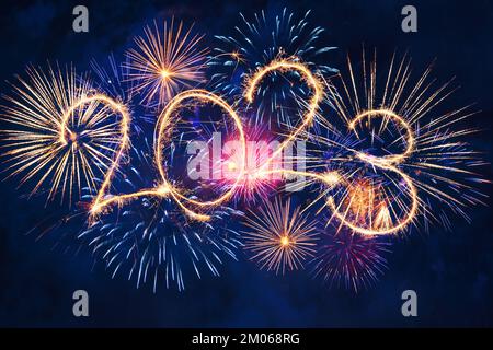 2023 concept de bonne année avec des étincelles dans le ciel nocturne. Feu d'artifice brillant sur fond noir pour bannière Banque D'Images